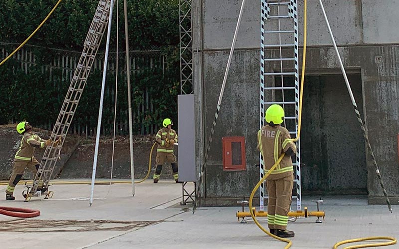 Trainee firefighters in position at the bottom of the drill tower.