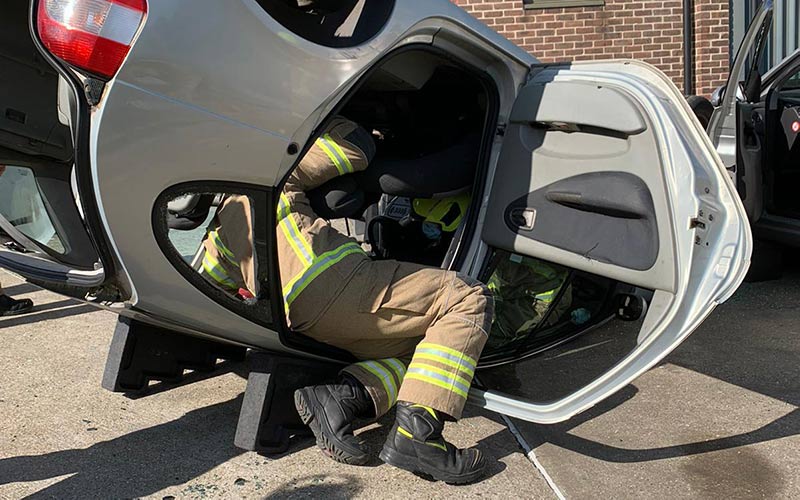 Two trainee firefighters in an overturned car.